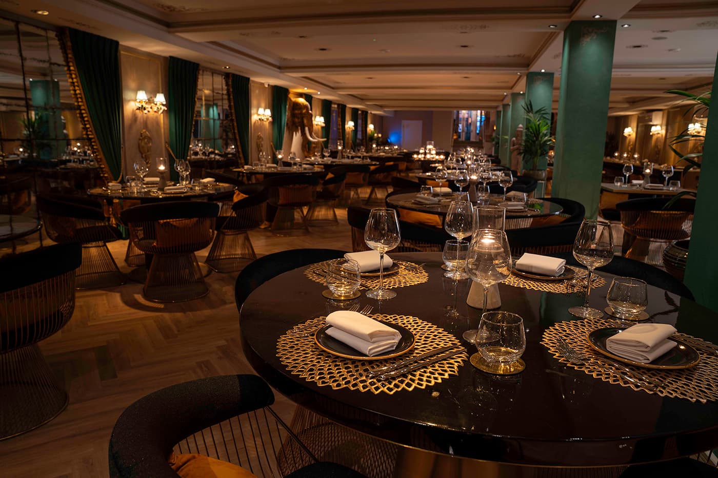 The Leicester dining room, laid tables running between green pillars