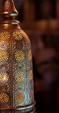 A pierced brass lantern glowing against the dining room wall