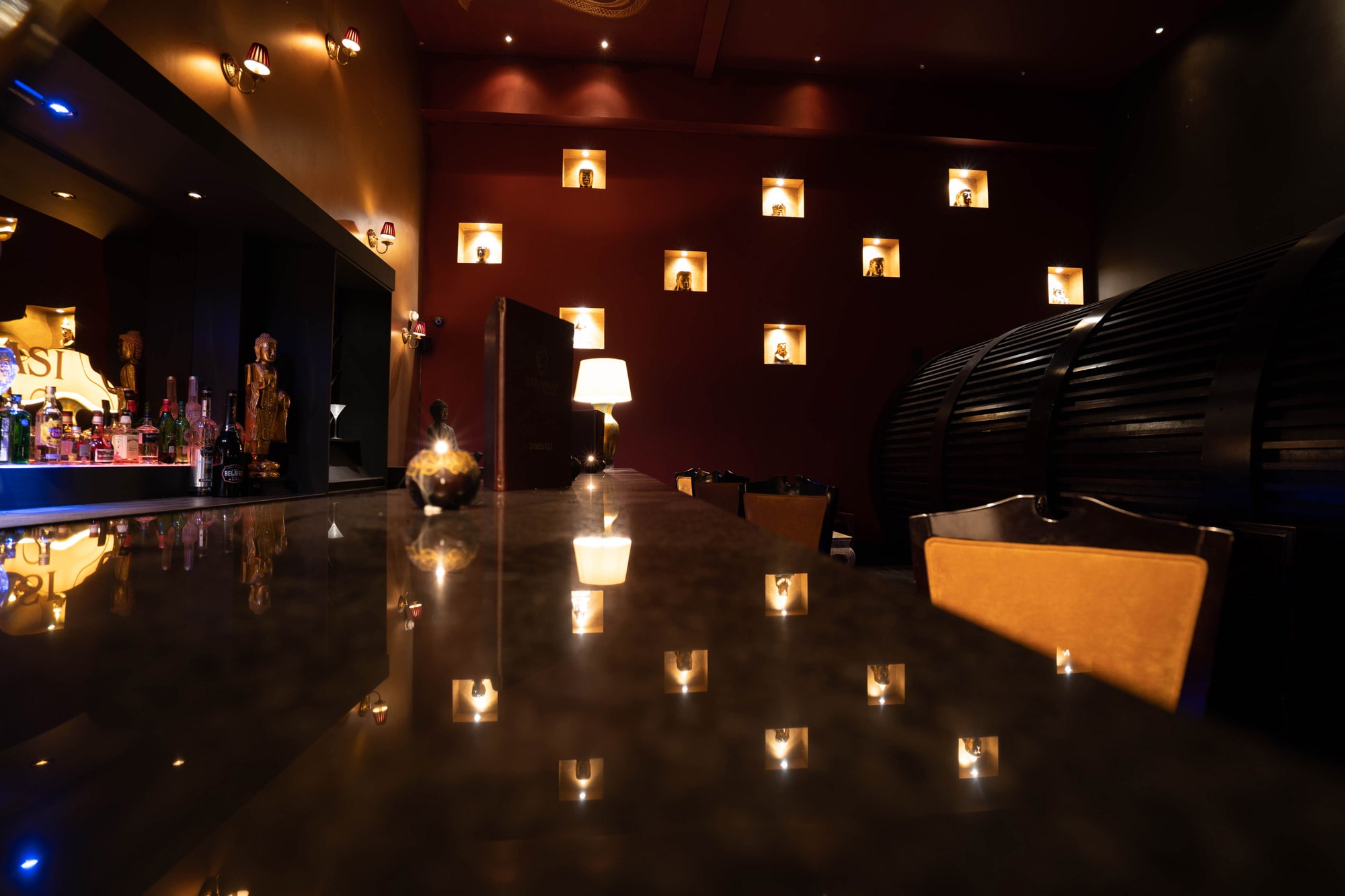 The dining room at night, candle lanterns reflected along a polished bar
